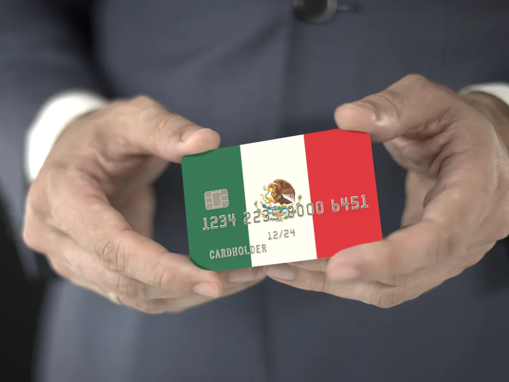 Una persona sostiene una tarjeta de crédito expedida en México