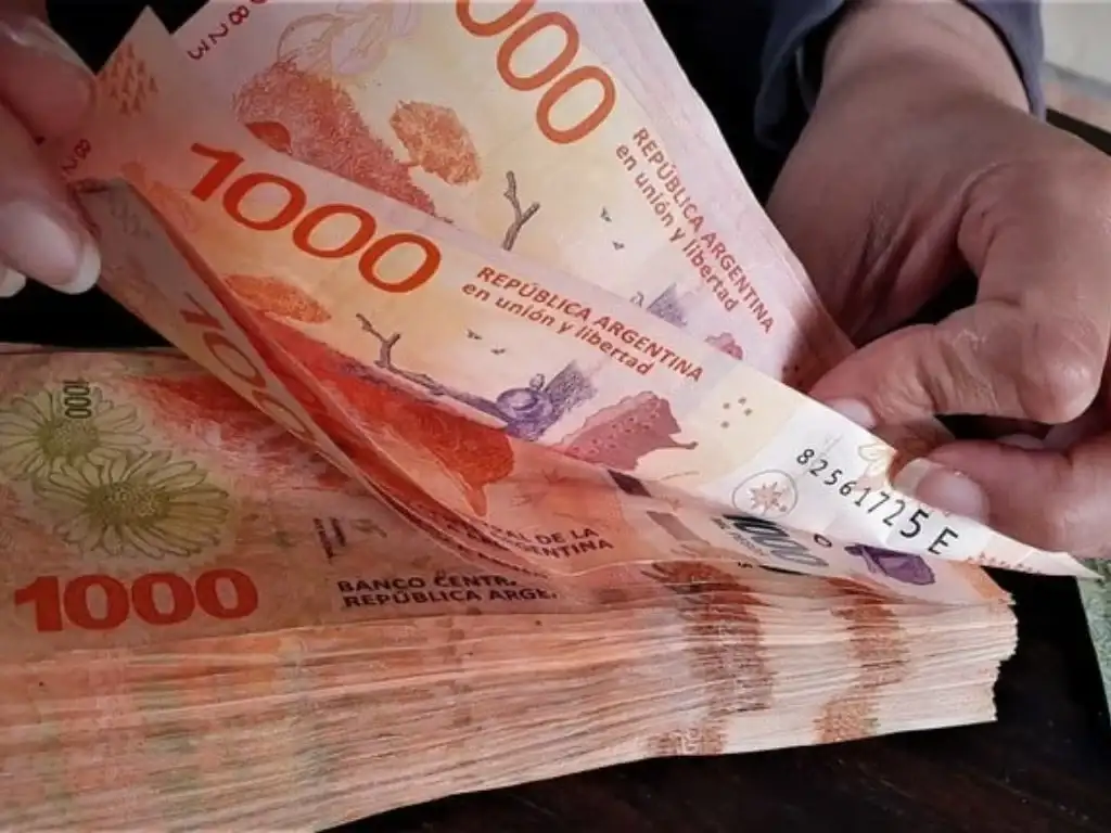 Una persona cuenta billetes de 1000 pesos