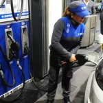 Una empleada carga nafta en una estación de servicio