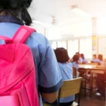 Una alumna ingresa a un aula