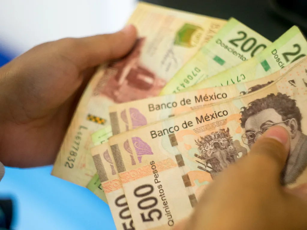 Una persona sostiene pesos mexicanos