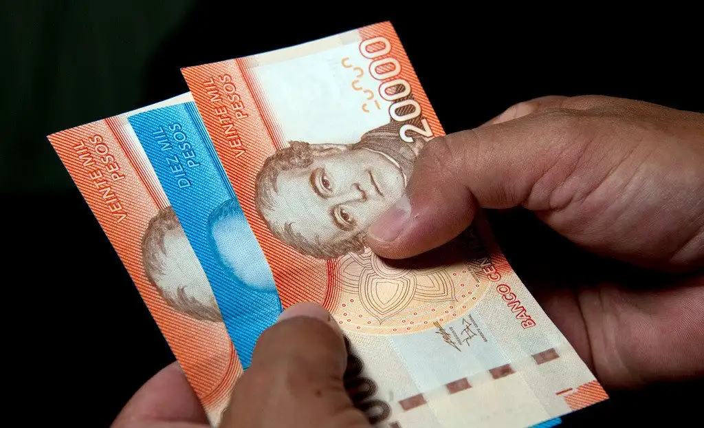 Una persona sostiene pesos chilenos
