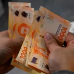 Una persona cuenta billetes de 1000 pesos
