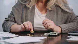 Persona calcula sus deudas con tarjetas de crédito sobre la mesa