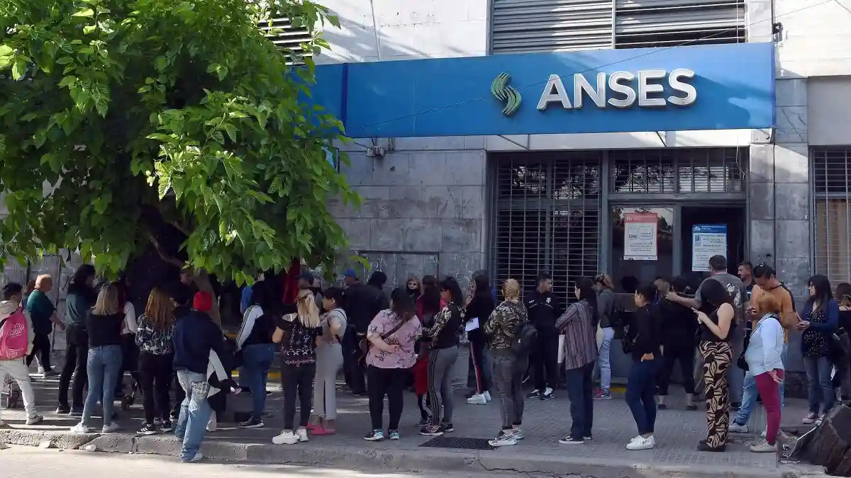 Personas hacen fila afuera de una sucursal de ANSES