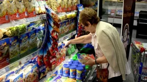 Jubilado haciendo compras en supermercado con carrito