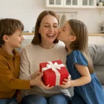 Madre sonriendo mientras recibe un regalo por el Día de la Madre.
