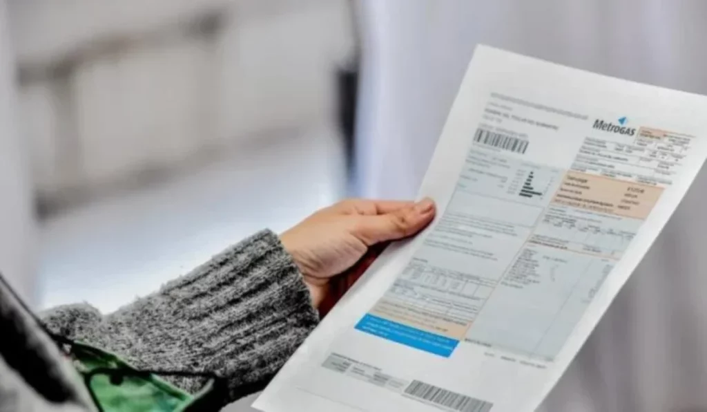 Persona revisando factura de gas en el hogar, preparando el pago del servicio