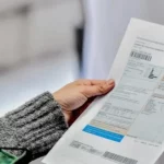 Persona revisando factura de gas en el hogar, preparando el pago del servicio