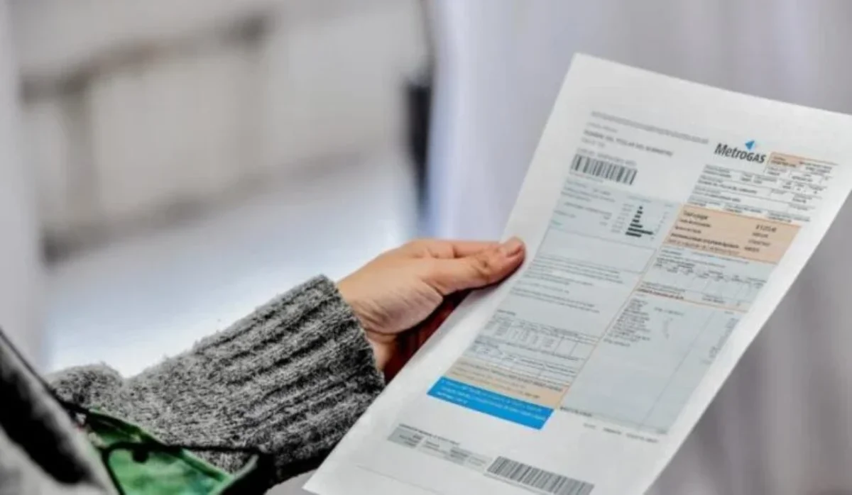 Persona revisando factura de gas en el hogar, preparando el pago del servicio