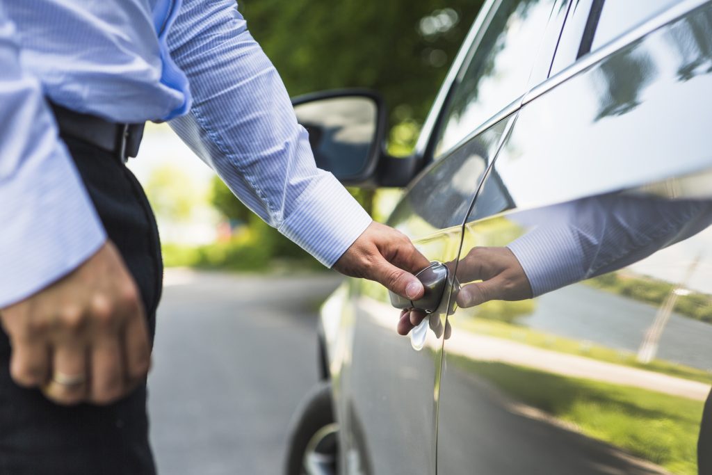 Una persona abre la puerta de su auto