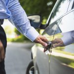 Una persona abre la puerta de su auto
