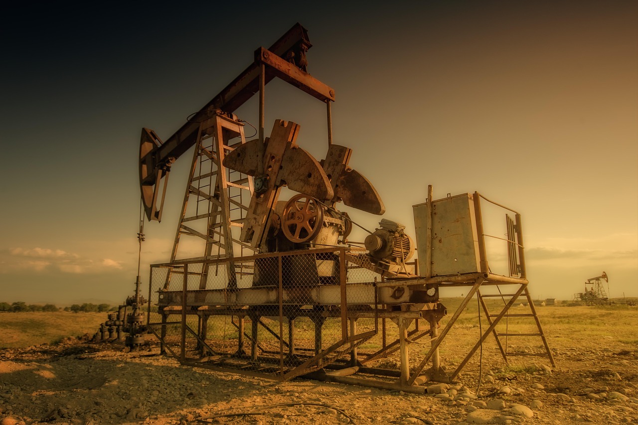 Torres de extracción de petróleo al atardecer en un campo petrolero.
